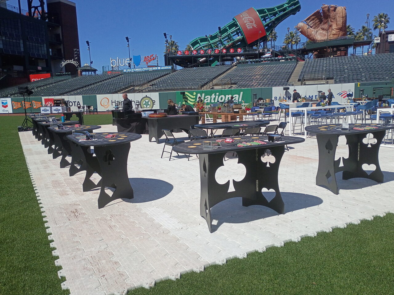Custom spade and club casino tables set up on the field at Oracle Park in San Francisco