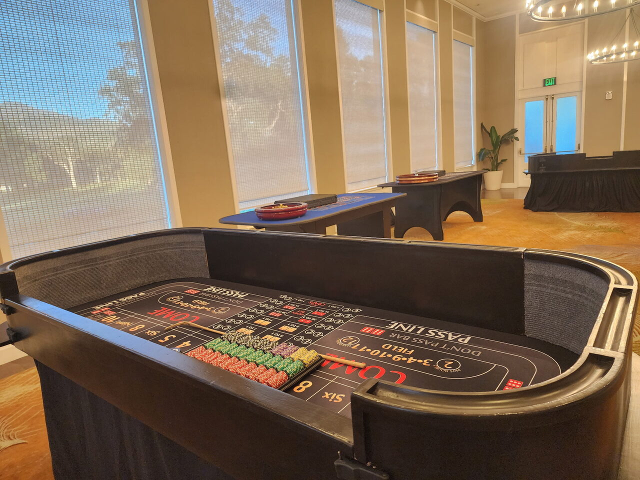 Craps table by floor-to-ceiling windows with a garden view at a Bay Area venue